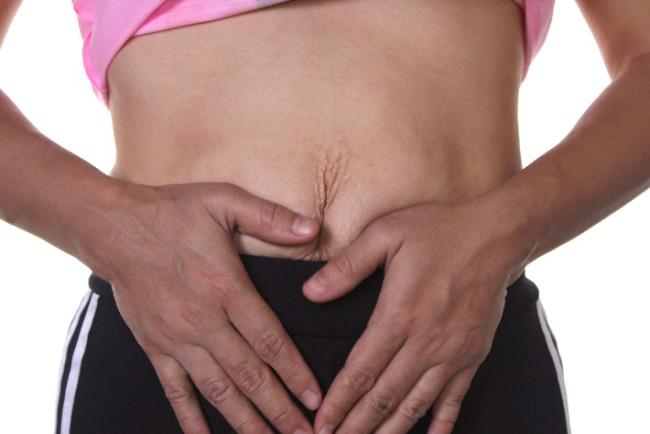 אישה סובלת מרפיון העור באזור הבטן אחרי הריונות ולידות